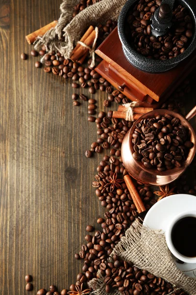 Cup of coffee, pot and grinder on wooden background — Stock Photo, Image