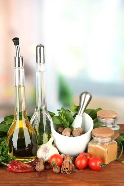 モルタル、オリーブ オイルと酢は、明るい背景に緑のハーブとボトルの組成 — ストック写真