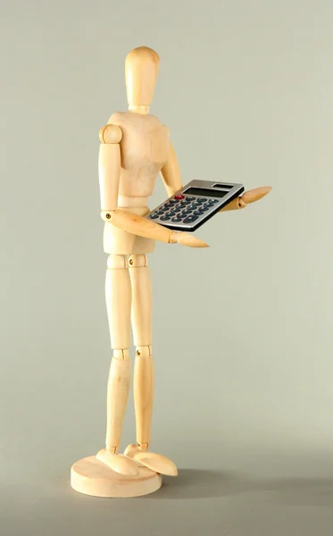 Wooden mannequin with calculator on grey background — Stock Photo, Image