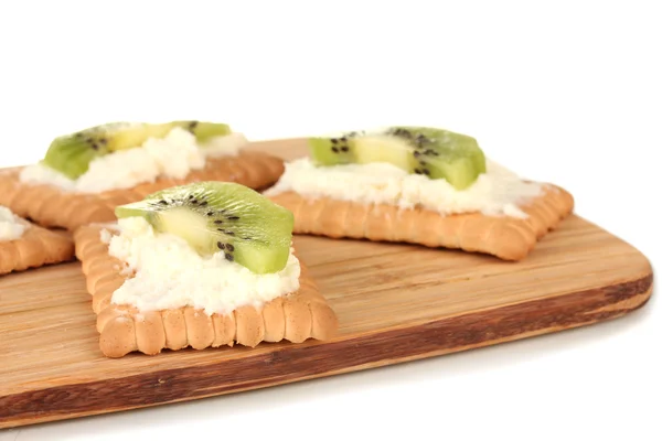 Pan crujiente con queso y kiwi, sobre tabla de cortar, aislado sobre blanco — Foto de Stock