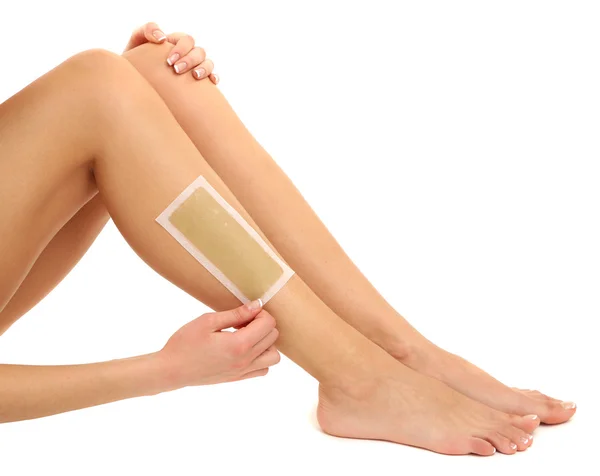 Beautiful woman doing depilation for her legs with waxing, isolated on white — Stock Photo, Image