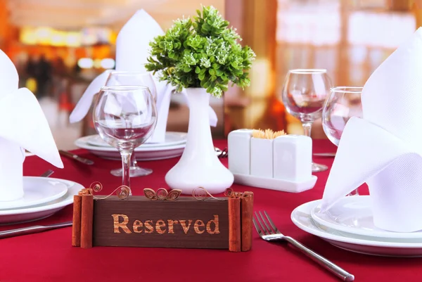 Зарезервований знак на столі ресторану з порожніми посудом і окулярами — стокове фото