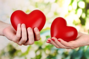 kadın ve adam ellerini, yeşil zemin üzerine kırmızı Kalpler