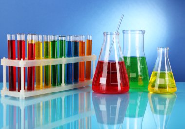 test tüpleri ile mavi arka plan üzerinde renkli sıvı