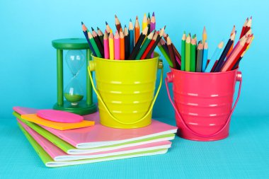 okul malzemeleri mavi arka plan ile renkli kalemler