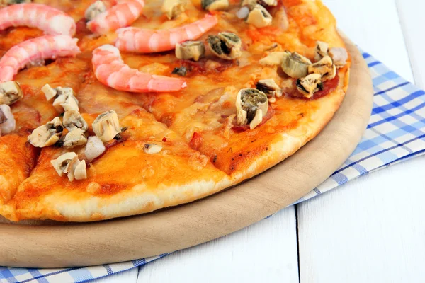 Leckere Pizza mit Meeresfrüchten am Stand auf Holzgrund — Stockfoto