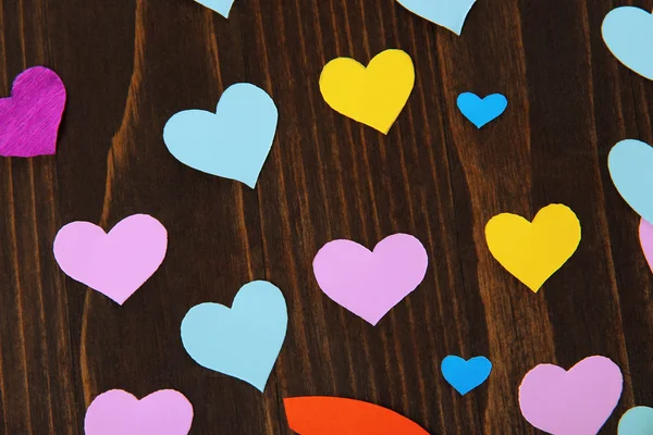 Много разноцветных бумажных сердец на деревянном столе крупным планом — стоковое фото