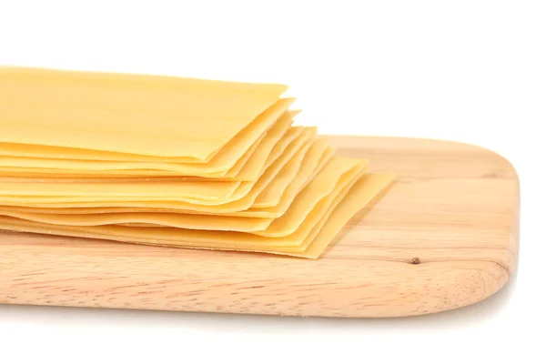 Pasta de lasaña sin cocer sobre tabla de cortar aislada en blanco —  Fotos de Stock