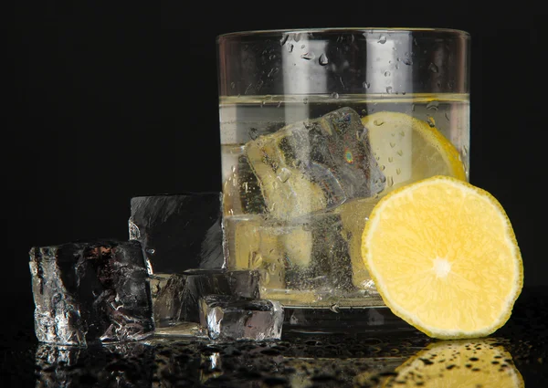 Cubes de glace en verre avec citron isolé sur noir — Photo