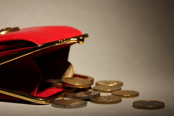 Billetera roja femenina con monedas sobre fondo gris — Foto de Stock