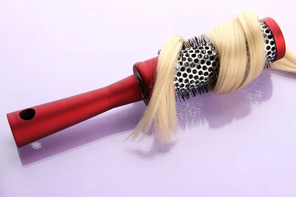 Peigne brosse avec cheveux, sur fond violet — Photo