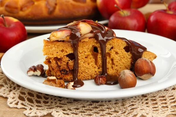 Slice of tasty homemade pie with chocolate and apples, on wooden table — Stock Photo, Image