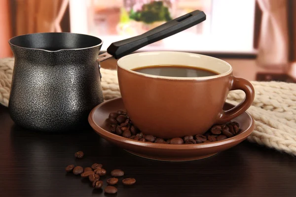 Cup of coffee with scarf and coffee maker on table in room — Stock Photo, Image