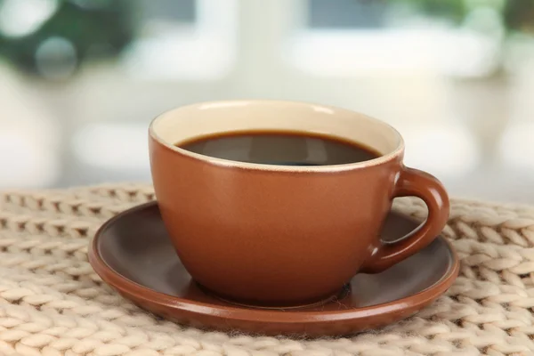 Чашка кофе с шарфом на столе в номере — стоковое фото