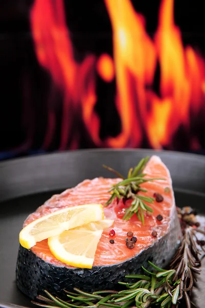 Steak z čerstvého lososa na pánvi, na pozadí ohně, zblízka — Stock fotografie