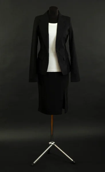 Біла блузка і чорна спідниця з пальто на манекені на чорному тлі — стокове фото