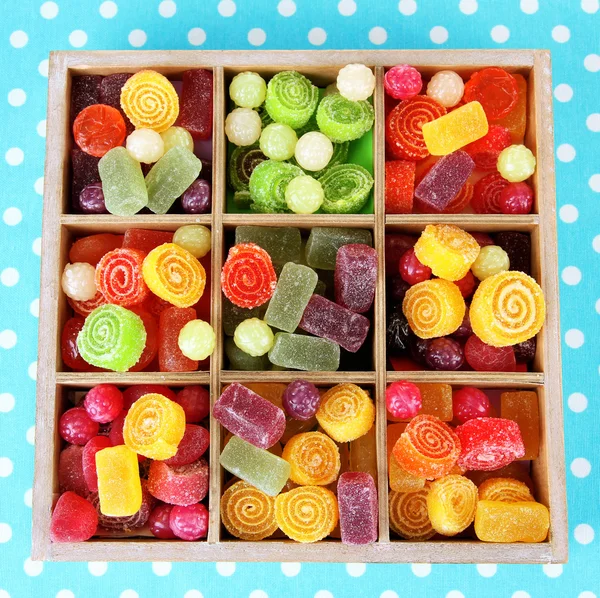 Multicolor cukierki w drewnianym pudełku, na kolor tła — Zdjęcie stockowe