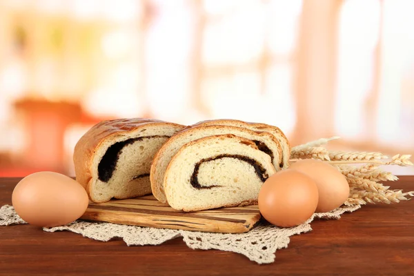 Loaf with poppy seed on cutting board, on bright background — Stock Photo, Image