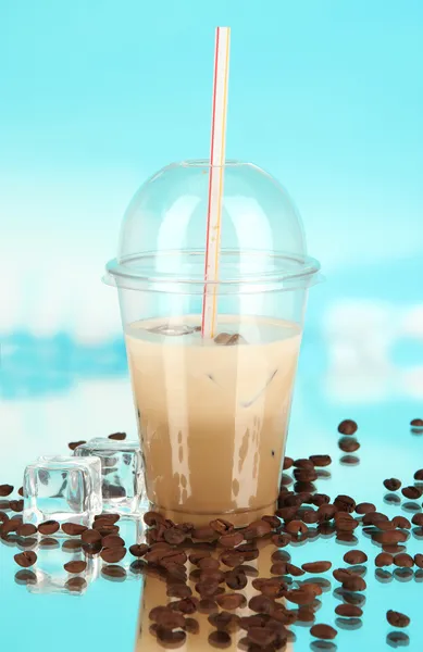 Cold coffee with ice in glass on blue background — Stock Photo, Image