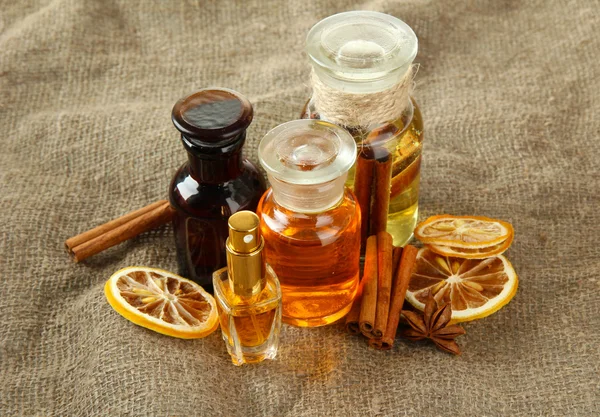 Botellas con ingredientes para el perfume sobre fondo de arpillera —  Fotos de Stock