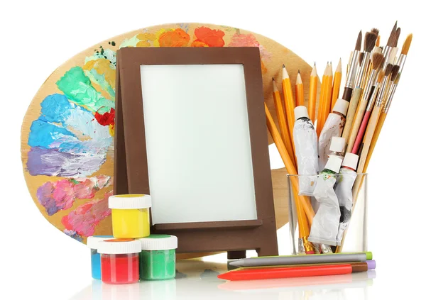 Photo frame as easel with artist's tools isolated on white — Stock Photo, Image