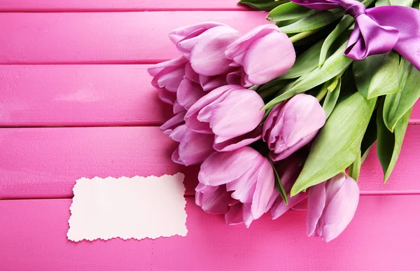 Beautiful bouquet of purple tulips on pink wooden background — Stock Photo, Image