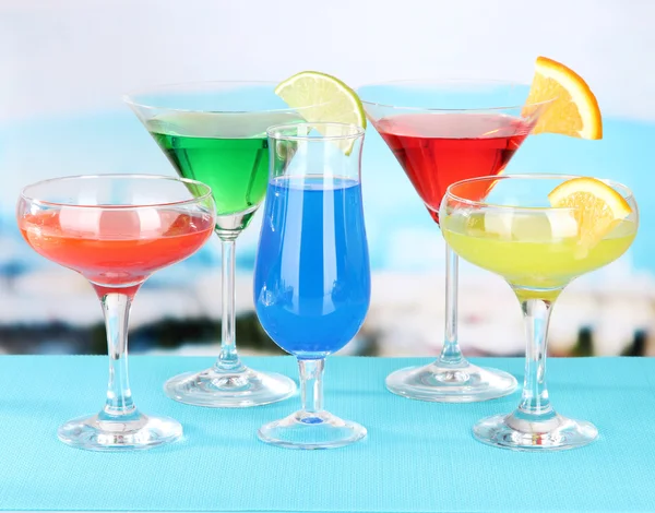 Glasses of cocktails on table near pool — Stock Photo, Image