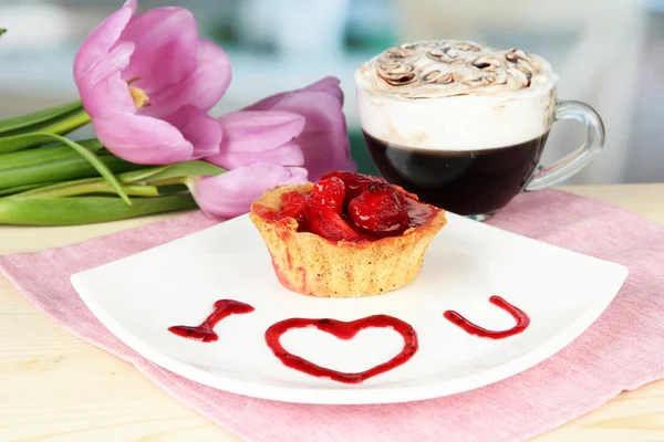 Söt tårta med jordgubbar och sås på tallrik, med kaffe, på ljus bakgrund — Stockfoto
