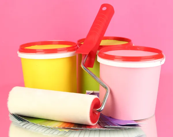 Set pour peinture : pots de peinture, rouleau de peinture, palette de couleurs sur fond rose — Photo