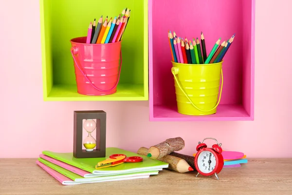 Lápis coloridos em pails em prateleiras no fundo bege — Fotografia de Stock