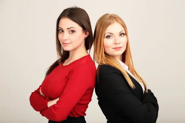 Zwei Geschäftsfrauen auf grauem Hintergrund — Stockfoto