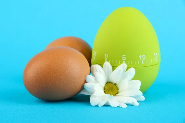 Grüne Eieruhr und Eier, auf farbigem Hintergrund — Stockfoto