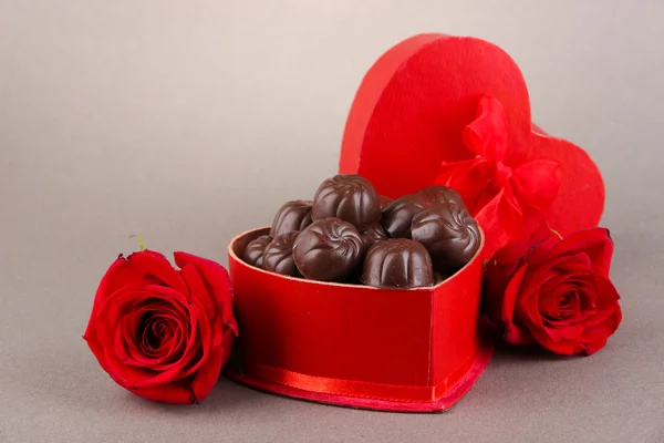 Dulces de chocolate en caja de regalo, sobre fondo gris — Foto de Stock