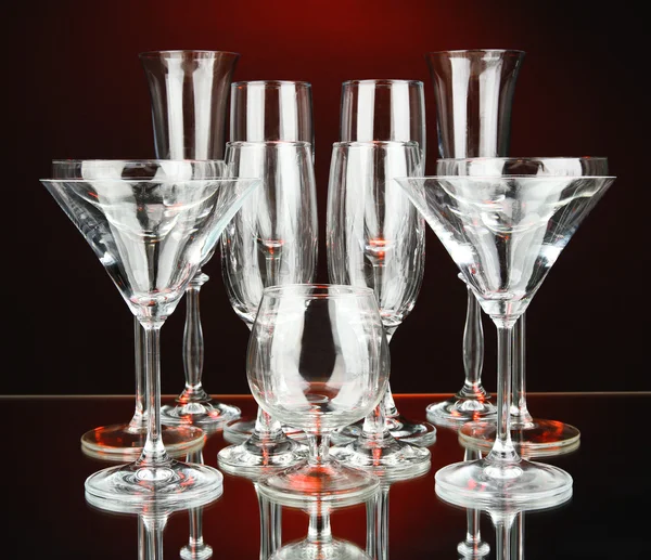 Bicchieri da cocktail e da vino, su sfondo rosso scuro — Foto Stock