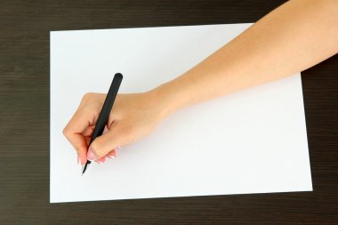 ahşap zemin üzerinde beyaz kağıt kalem ile el