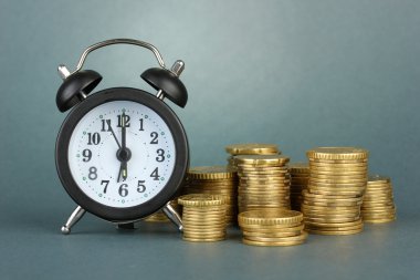 gri arka plan üzerinde paralar ile çalar saat