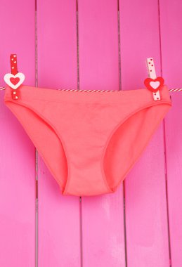 bir clothesline üzerinde pembe ahşap arka plan asılı womans külot