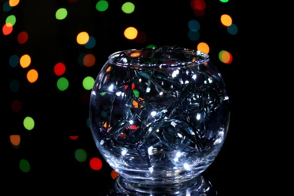 Christmas lights in glass bowl on blur lights background — Stock Photo, Image