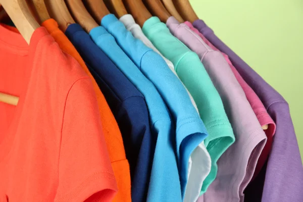 Variety of casual shirts on wooden hangers,on blue background — Stock Photo, Image