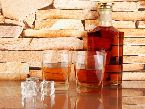 Flasche und Gläser Whiskey und Eis auf Backsteinmauer Hintergrund — Stockfoto