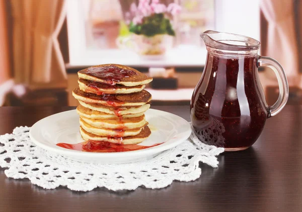 Süße Pfannkuchen auf dem Teller mit Marmelade auf dem Tisch im Zimmer — Stockfoto