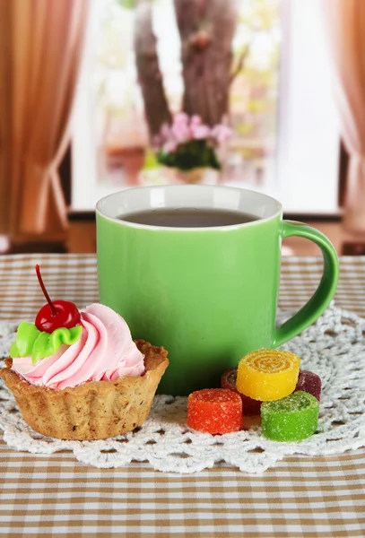 Taza de té con pastel y dulces en la mesa en la habitación —  Fotos de Stock