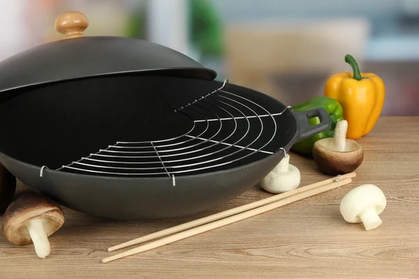 Poêle à wok noir et légumes sur la table de cuisine, gros plan — Photo