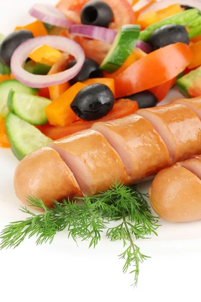 На грилі ковбаса зі свіжим салатом крупним планом — стокове фото