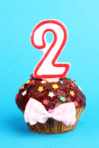 Birthday cupcake with chocolate frosting on blue background — Stock Photo, Image