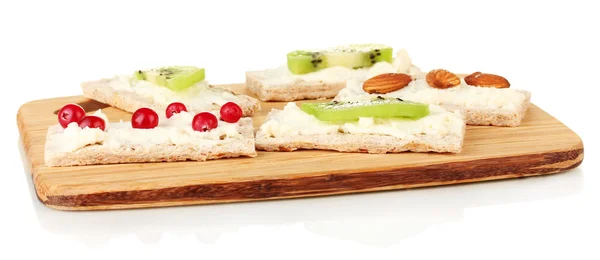 Tasty canapes with cheese, kiwi and cranberry, on cutting board, isolated on white — Stock Photo, Image