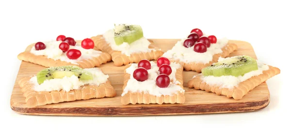 Canapés saborosos com queijo, kiwi e cranberry, sobre tábua de corte, isolados sobre branco — Fotografia de Stock