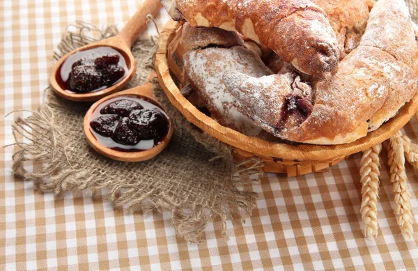 Taste croissants in basket and jam on tableclot — Stock Photo, Image