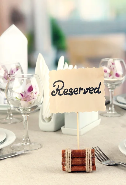 Gereserveerde teken op restaurant tafel met lege servies en glazen — Stockfoto