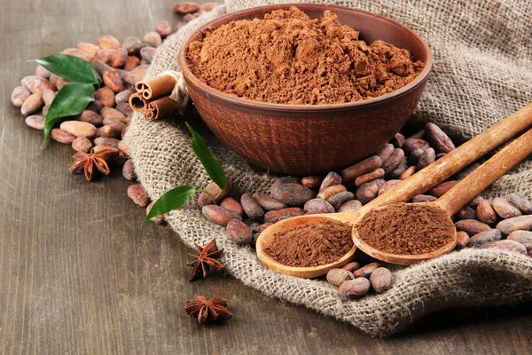 Cacaopoeder en cacaobonen op houten achtergrond — Stockfoto